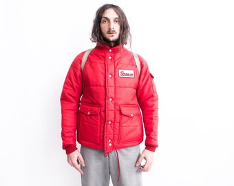 May include: A red quilted jacket with a Snap-on logo patch. The jacket has a zipper closure and two large pockets on the front.
