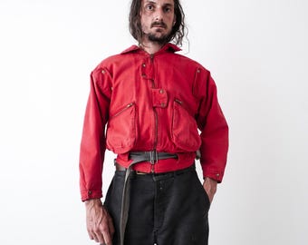 Chaqueta bomber corta estilo cargo utilitario de los años 80. Cierre frontal con doble botón a presión.