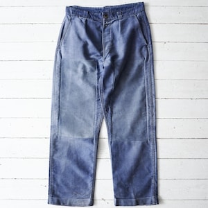 May include: A pair of blue corduroy trousers featuring a high-waisted design with a single button closure, a zippered fly, and reinforced rectangular knee patches. The fabric displays a faded, worn-in texture with visible vertical corded lines.