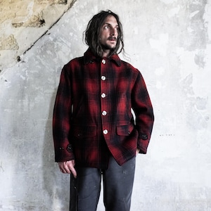 Peut inclure: Une veste à manches longues avec un motif à carreaux rouge et noir, un col pointu et une fermeture à boutons sur le devant. Le vêtement comprend deux poches avant inférieures avec rabats et boutons, ainsi que des poignets boutonnés sur chaque manche.