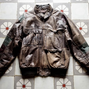 Veste en cuir effet vieilli patchwork design asymétrique des années 1980. Blouson aviateur punk