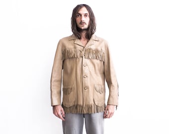 Peut inclure: Une veste en cuir beige avec des détails en franges. La veste a une fermeture boutonnée à l'avant et des manches longues.