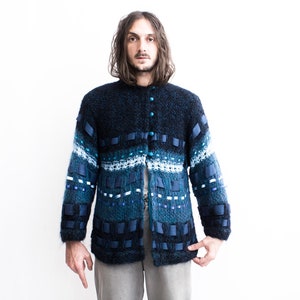 Peut inclure: Un cardigan bleu et blanc &agrave; motifs avec une fermeture boutonn&eacute;e. Le cardigan est fait d'un mat&eacute;riau doux et duveteux.