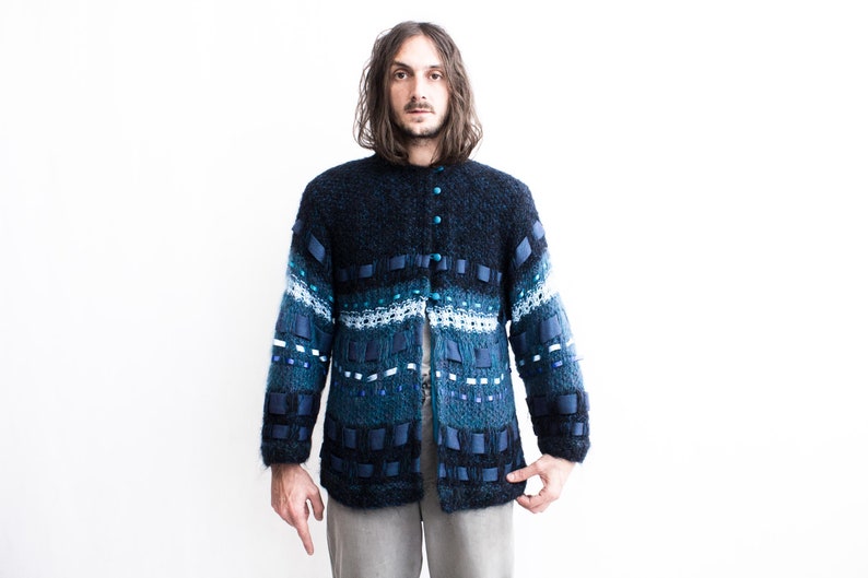 Peut inclure: Un cardigan bleu et blanc &agrave; motifs avec une fermeture boutonn&eacute;e. Le cardigan est fait d'un mat&eacute;riau doux et duveteux.