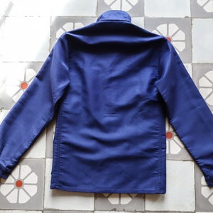 May include: A dark blue long-sleeved work jacket with a button-up collar and a straight hem.