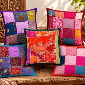 May include: Five square throw pillows featuring patchwork designs with intricate embroidery and varied fabric textures. The cushions display a vibrant color palette including shades of purple, orange, red, pink, and blue, with detailed stitching patterns.