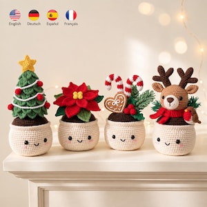 May include: Four crocheted festive decorations in cream-coloured pots with smiling faces. The set includes a green Christmas tree with a yellow star, a red poinsettia, a gingerbread heart with candy canes, and a brown reindeer with a red scarf.