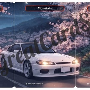 Può includere: Un'auto sportiva bianca parcheggiata su una strada di notte, circondata da alberi di ciliegio in fiore. Un distributore automatico con testo giapponese si trova nelle vicinanze. Paesaggio montano sotto un cielo notturno, con la scritta Mountain.