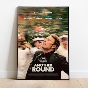 May include: A movie poster for Another Round featuring a man in a black suit looking upward with a blurred background of people and motion. The text reads A FILM BY THOMAS VINTERBERG, MADS MIKKELSEN, THOMAS BO LARSEN, MAGNUS MILLANG, LARS RANTHE, and ANOTHER ROUND.