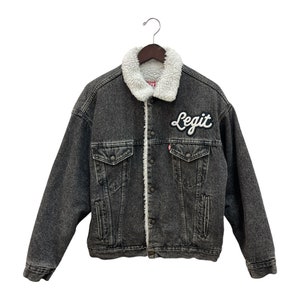 May include: A black denim jacket with a sherpa lining and a white "Legit" patch on the left chest.