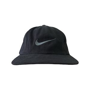 May include: A black baseball cap with a white Nike swoosh logo.