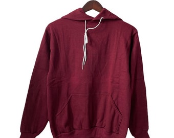 May include: A maroon hooded sweatshirt with a white drawstring. The sweatshirt has a kangaroo pocket on the front.