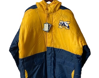May include: A yellow and blue hooded jacket with a large embroidered "M" on the front. The jacket has a zipper closure and two pockets on the front. The tag on the jacket says "XL".