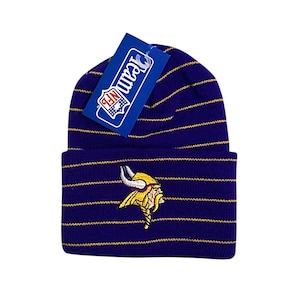 Op de afbeelding: Paarse en gouden gestreepte gebreide beanie met het logo van de Minnesota Vikings geborduurd op de voorkant. De beanie heeft een label met de tekst "Team NFL".