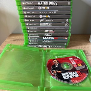 May include: A stack of fifteen Xbox One video game cases with titles including Skyrim, Battlefield 1, Watch Dogs, FIFA 17, Destiny, FIFA 18, Forza 5, Battlefront, Elder Scrolls Online, Forza Horizon 2, Fallout 4, Mafia III, FIFA 19, Shadow of Mordor, and Call of Duty Ghosts.
