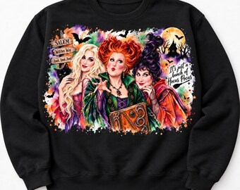 Könnte beinhalten: Ein schwarzes Sweatshirt mit einer farbenfrohen Aquarell-Grafik von drei Hexen. Das Design enthält den Text Salem, Witches Way, Amok, Amok, Amok! und It's just a bunch of Hocus Pocus sowie eine schwarze Katze, Fledermäuse und einen Mond.