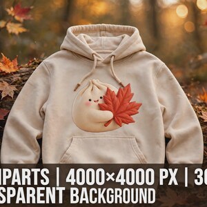 Peut inclure: Un sweat à capuche beige orné d'un motif représentant un petit personnage rond et souriant tenant une grande feuille d'érable rouge vif. Le sweat comprend une poche kangourou à l'avant et des cordons de serrage beiges assortis.
