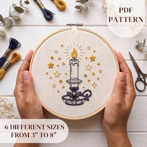 May include: An embroidery hoop containing a fabric piece with a stitched design of a lit candle in a holder surrounded by stars. The text PDF PATTERN and 6 DIFFERENT SIZES FROM 3" TO 8" are visible. Embroidery floss and scissors are nearby.