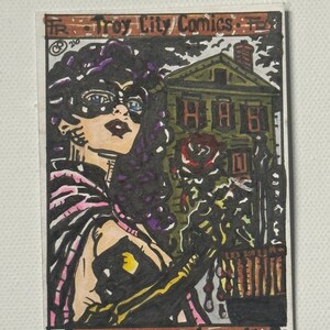 Könnte beinhalten: Ein handgezeichnetes Comic-Cover mit dem Titel Troy City Comics Black Dahlia Series 105BDSE. Es zeigt eine maskierte Figur mit dunklem lockigem Haar, einem schwarzen Umhang und einer roten Rose vor einem grünen Haus mit schwarzen Tintenumrissen.
