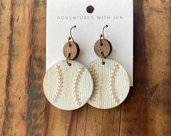 May include: White wooden earrings with a baseball design and brown wooden accents. The earrings are labeled "Adventures with Jen".