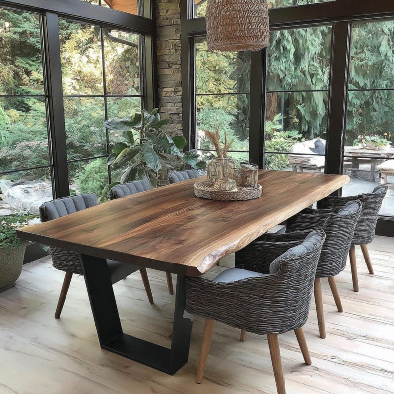 Puede incluir: Una mesa de comedor rectangular con tablero de madera oscura de borde natural y base de metal negro en forma de U. Seis sillas trenzadas grises con patas de madera clara est&aacute;n dispuestas alrededor. Una bandeja trenzada sostiene jarrones.
