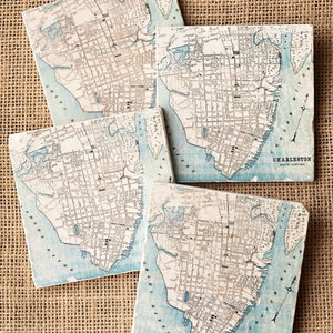 May include: Set of four square coasters featuring vintage maps of Charleston, South Carolina. The coasters are made of ceramic and have a light blue and white color scheme.