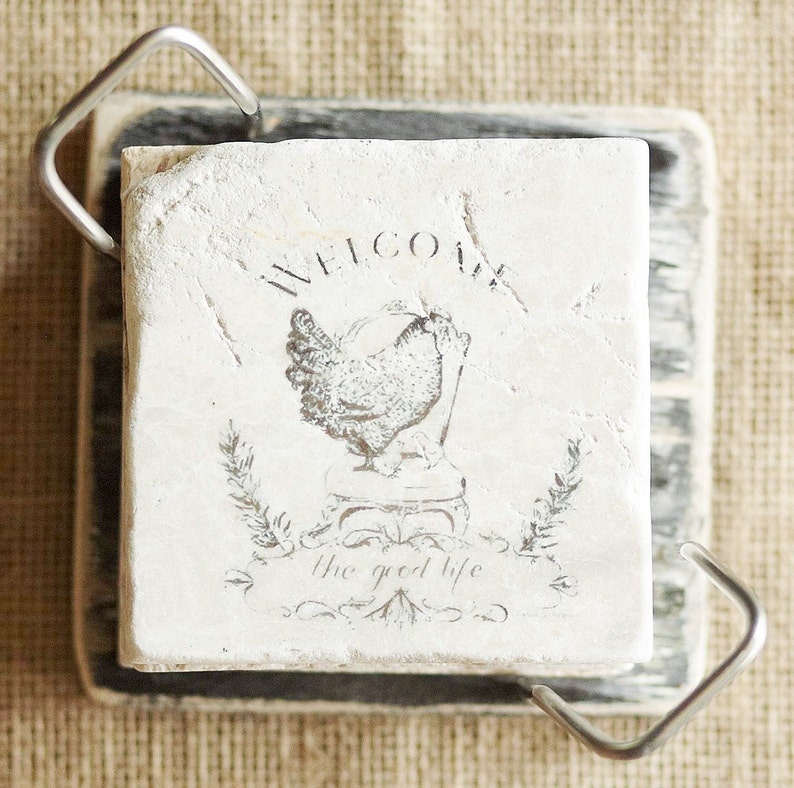 May include: White ceramic coaster with a black and white image of a chicken and the text "Welcome the good life".