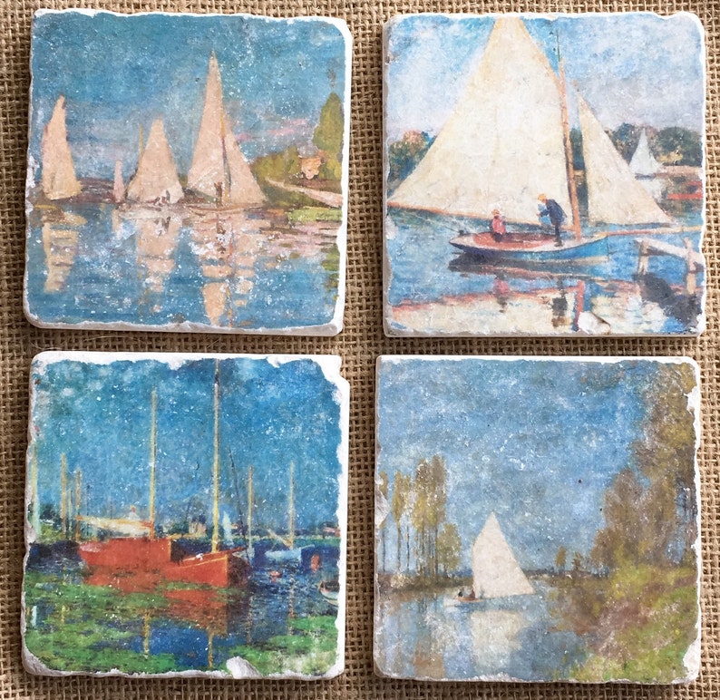 May include: Set of four square coasters featuring vintage-style paintings of sailboats on water. The coasters are made of natural stone with a rustic, textured surface.