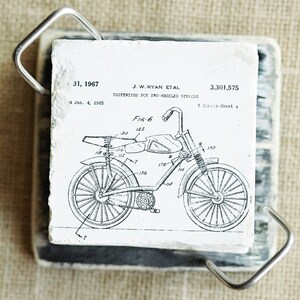 K&ouml;nnte beinhalten: Schwarz-wei&szlig;-Linienzeichnung eines Motorrad-Federungssystems. Das Patent tr&auml;gt den Titel "Federung f&uuml;r Zweir&auml;der" und ist vom 4. Januar 1965. Die Patentnummer lautet 3.301.575.