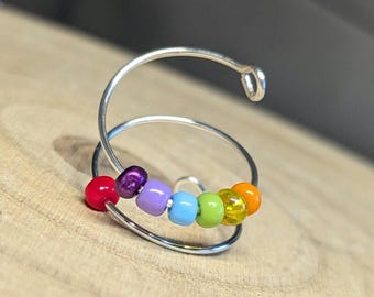 May include: A silver hoop earring with a rainbow of colored beads. The beads are red, purple, light blue, green, yellow, and orange.