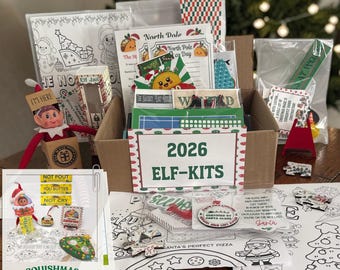 Könnte beinhalten: Ein Pappkarton gefüllt mit 2026 Elf-Kits, inklusive Malvorlagen, kleinen Schildern und Zubehör. Das Set enthält eine kleine Elfenpuppe, eine mit Elf Jail beschriftete Schachtel und verschiedene bedruckte Karten mit weihnachtlichen Motiven und Texten.