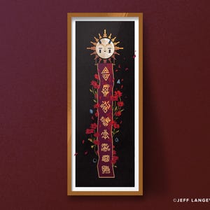 May include: A framed art print featuring a stylized sun face with a banner of symbols and red flowers against a black background. The banner has text in a unique font. The artwork is in a wooden frame.