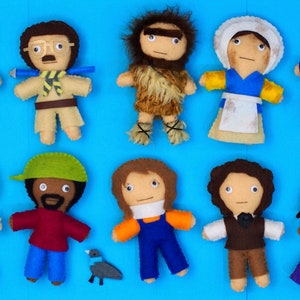May include: Ten felt dolls, each depicting a different person, are arranged on a blue background. The dolls are all handmade and have unique features, with different outfits and hairstyles.