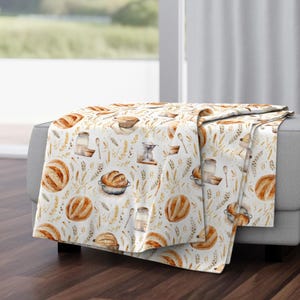 Soft baking quilt or blanket made from vintage farmhouse bread fabric, featuring French sourdough loaves, countryside wheat, and rustic beige tones for cozy home style
