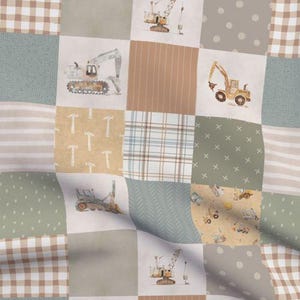 May include: A patchwork fabric with illustrations of construction vehicles in beige, brown, and green. The design includes excavators, cranes, and other machinery, set against a backdrop of patterned squares. The fabric is suitable for various craft projects.