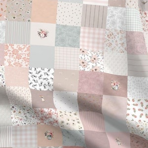 May include: A patchwork quilt fabric featuring a variety of floral patterns in shades of pink, white, and gray. The fabric is made up of squares of different sizes and patterns, creating a unique and whimsical design.