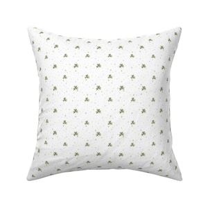 Puede incluir: Almohada blanca con un patr&oacute;n de tr&eacute;bol verde. Los tr&eacute;boles son peque&ntilde;os y est&aacute;n espaciados uniformemente.