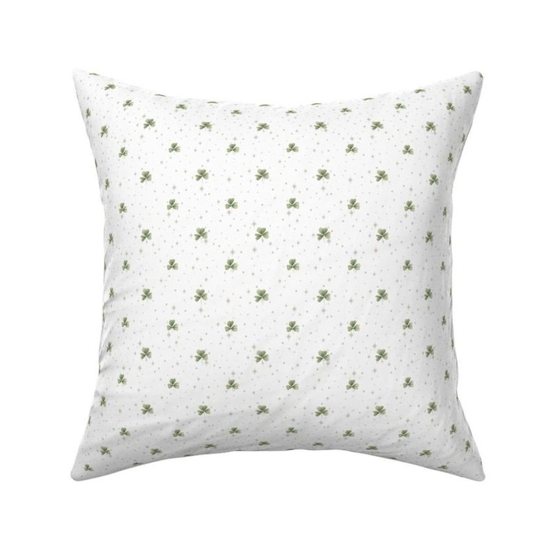 Puede incluir: Almohada blanca con un patr&oacute;n de tr&eacute;bol verde. Los tr&eacute;boles son peque&ntilde;os y est&aacute;n espaciados uniformemente.