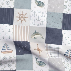 May include: A blue and white patchwork fabric with nautical themed designs. The fabric features anchors, whales, sailboats, a compass, and a steering wheel.