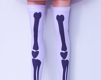 May include: A pair of lavender thigh-high socks with a black skeleton bone print.