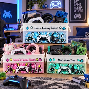 May include: Three rectangular fabric storage baskets with rope handles, each featuring a personalized name and gaming-themed graphics including controllers, headsets, and pixelated icons. The baskets are light blue, pink, and light green.