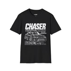 May include: A black short-sleeve t-shirt featuring a white graphic print of a Toyota JZX100 Chaser car. The design includes the text CHASER TOYOTA JZX100, Japanese characters, and smaller inset images of car details and technical specifications.