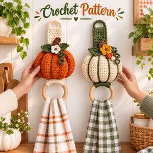 May include: Two crochet pumpkin towel hangers with wooden rings and hanging kitchen towels. The left hanger is orange with a white flower, and the right is cream with a yellow flower. Text at the top reads Crochet Pattern.