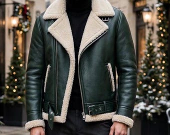 May include: A dark green leather jacket with a thick cream-colored shearling lining, a wide notched collar, silver-tone metal zippers, and an adjustable buckled belt at the hem, worn over a black turtleneck sweater and dark trousers.