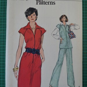 Pode incluir: Um padrão de costura vintage para um vestido vermelho e um macacão azul claro. O padrão é da Very Easy Vogue Patterns e é tamanho 16, busto 99 cm. O número do padrão é 9451.