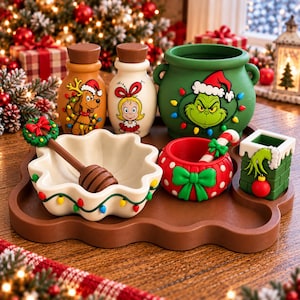 May include: A festive-themed set comprising a brown tray holding two bottles with character illustrations, a green cauldron, a white scalloped bowl with a honey dipper, a red polka-dot bowl with a candy cane, and a green chimney-shaped container.