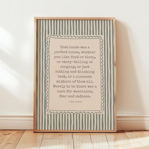 May include: A rectangular framed print featuring a beige central panel with a scalloped border, containing the text: That house was a perfect house, whether you like food or sleep, or story-telling or singing, or just sitting and thinking best, or a pleasant mixture of them all. Merely to be there was a cure for weariness, fear and sadness. -J.R.R. Tolkien. The background has vertical blue-grey stripes.