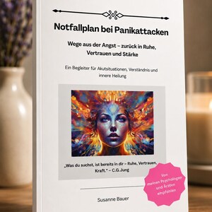 May include: A white book titled Notfallplan bei Panikattacken with the subtitle Wege aus der Angst - zurück in Ruhe, Vertrauen und Stärke. The cover features a colorful, abstract portrait of a face and a pink starburst label with German text.