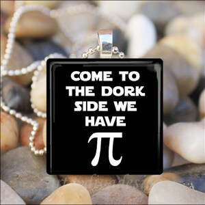May include: Black glass pendant necklace with a white inscription that reads "Come to the dork side we have pi".