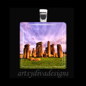 May include: A glass pendant featuring a photograph of Stonehenge, a prehistoric monument in Wiltshire, England. The image shows the stones against a backdrop of a purple and pink sunset sky.